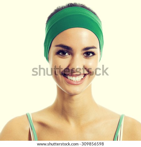 Cheerful young brunette woman in green fitness wear