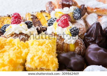 In the pictured typical italian pastries with cream,choccolate,rasperry and blackberry with various forms.