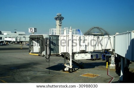 Jetway at an airport with control tower in the background.