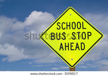 Sign at right of photo warning of school bus stop ahead...often found on rural roads