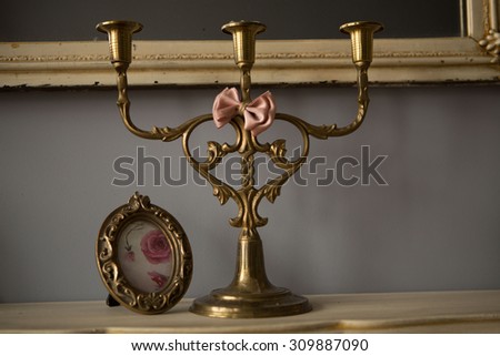 candlestick and photo frame with a stand on the mantelpiece