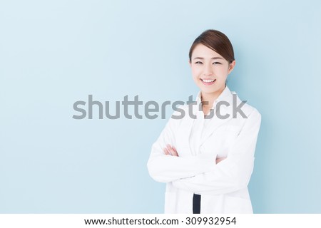 portrait of young asian doctor isolated on blue background