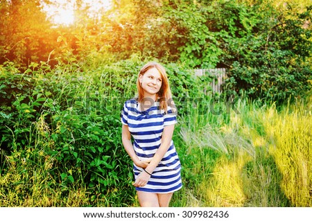 Portrait of the pregnant girl in the twilight of day. A big patch of light on a background. A bright sun through trees. Light picture of the pregnant girl.