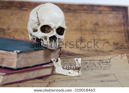 Human Skull and old text book on Old map Background