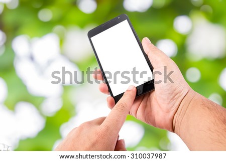 Man hand hold blank touch screen smart phone on Soft green natural bokeh background