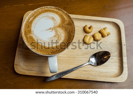 hot cup of coffee on wood board, with heart shape