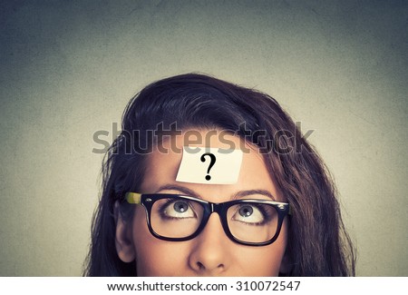 thinking woman with question mark on gray wall background Royalty-Free Stock Photo #310072547