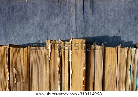 Pile of old books. A number of old books on a wooden surface close up
