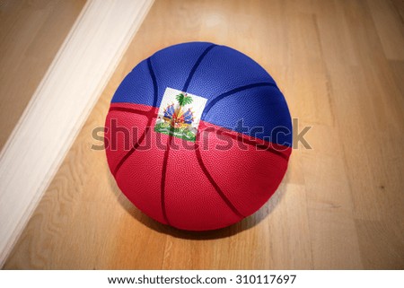 basketball ball with the national flag of haiti lying on the floor near the white line