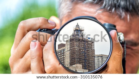 Photographer taking photo with DSLR camera at New York Buildings. Shallow DOF