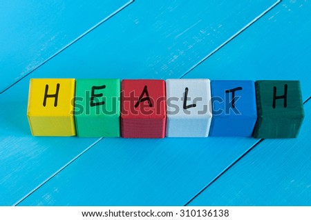 Health - word on children's colourful cubes or blocks. Colourful wooden background.
