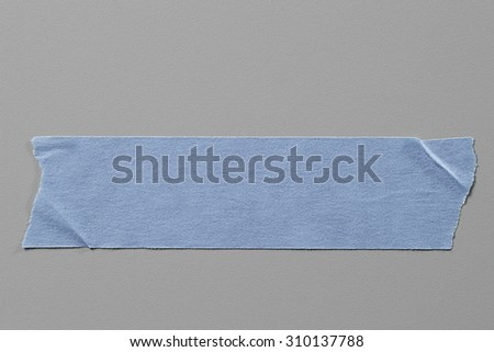 Blue Masking Tape on Grey Background with Real Shadow. Top View of Adhesive Tape, Label or Paper Tag. Sticker Close Up with Copy Space for Text or Image
