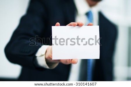 Man's hand showing business card - closeup shot on grey background