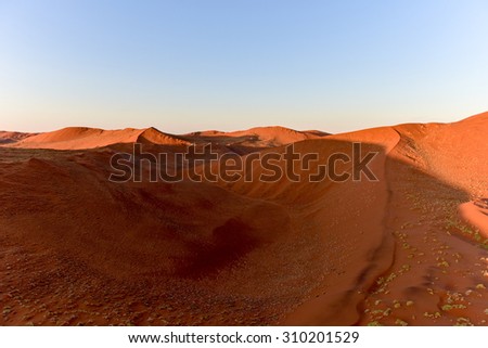 Aerial view of high red dunes, located in the Namib Desert, in the Namib-Naukluft National Park of Namibia.