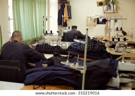 a sewing workshop - prisoners sew dark uniforms Royalty-Free Stock Photo #310219016