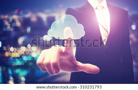 Business man with cloud computing concept on blurred city background