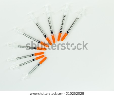 Fan of syringes on a white table