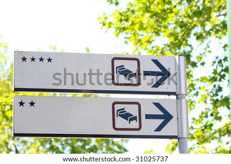 Hotel road signs with different stars on tree's green leaves background