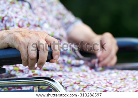 Picture of an elderly woman hand in a wheelchair