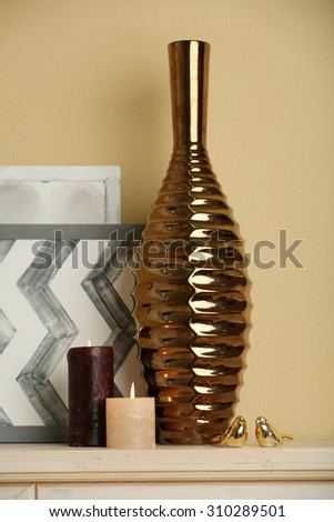 Modern vase with decor on fireplace in room