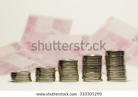 coin stacks with euro banknotes in the background.