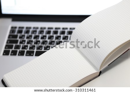 Laptop with empty white display, empty notebook