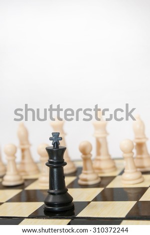 Black king against white figures in the chess.