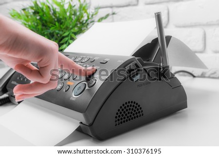Woman's hands using fax