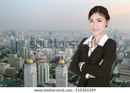 Business woman , crossed arms, with city background
