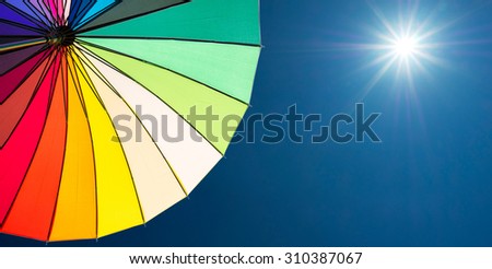 colorful umbrella segments on blue sky background
