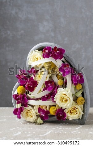 Floral arrangement with roses and orchids in heart shape