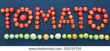 Word tomato written with green and red tomatoes on wooden background