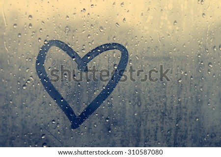 Autumn rain, the inscription on the sweaty glass - love and heart
