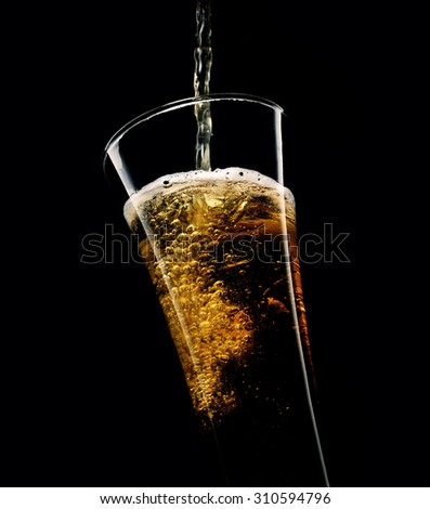 beer poured into a glass on a black background
 Royalty-Free Stock Photo #310594796