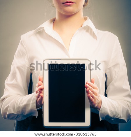 Elegant businesswoman holding blank screen showing copy space. Woman advertising new modern technology. Instagram filtered.