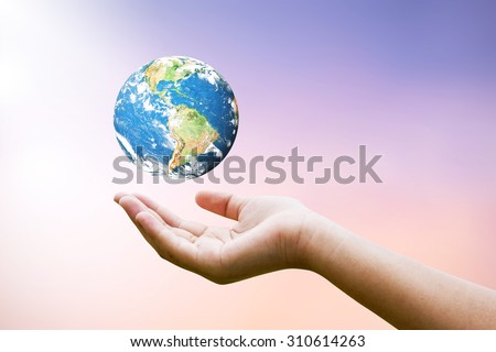 Female hands holding floating world on blurred sunset background with sun light : Elements of this image furnished by NASA