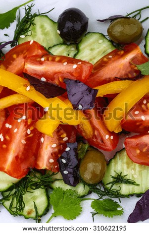 Salad with tomato, cucumber and olives served sesame seeds