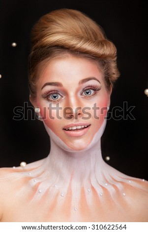 Woman surrounded by pearls in surrealistic concept photo. Studio shooting. Conceptual photography