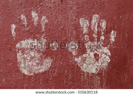 texture of white children's handprint by white paint on a red metallic fence