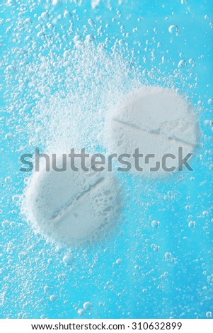 Effervescent painkiller tablets in water, closeup