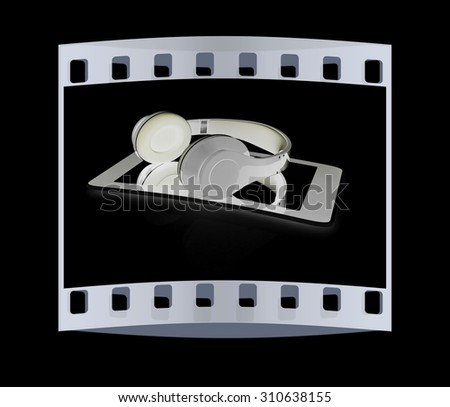 a creative cellphone with headphones isolated on black, portable audio concept. The film strip