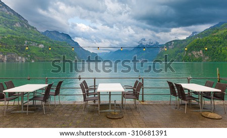 In the seaside cafe after rain. Empty tables and chairs
