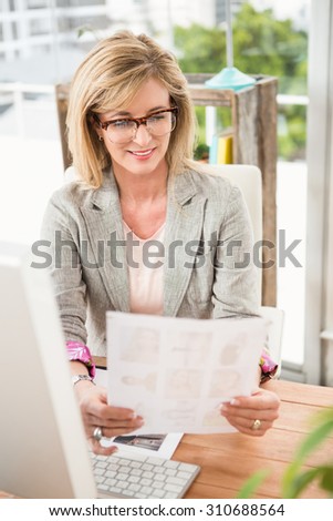 Smiling casual designer working at her desk in the office