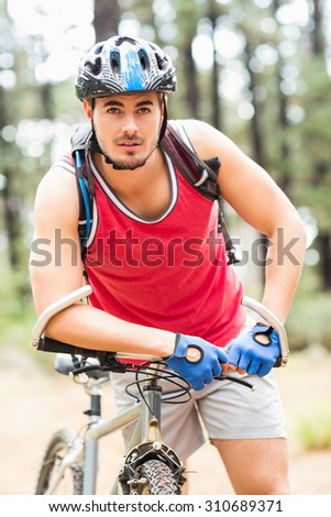 Handsome young biker looking at camera in the nature