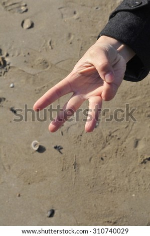 hand counting three on the beach