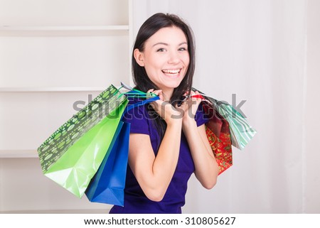 Smiling happy girl buys a bag gifts for Christmas - studio shoot 