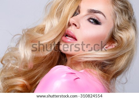 Beauty face of the young beautiful woman - isolated on white background. Gorgeous female portrait with slicked blond hair. Young adult girl with healthy skin. Pretty lady with fashion eye makeup. Royalty-Free Stock Photo #310824554