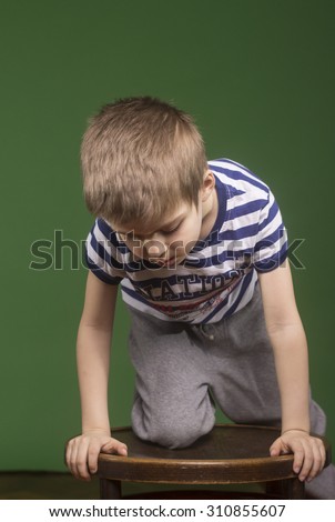 Boy kid climbing wooden chair. Chroma key background.