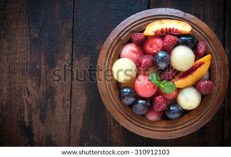 Fruits salad served on wooden background with blank space 