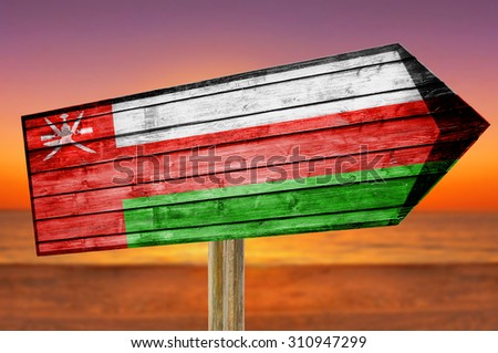 Oman Flag wooden sign on beach background